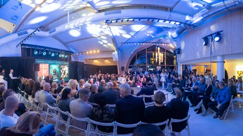 Panoramiczny widok pełnej sali eventowej połączonej z drewnianą strefą barową