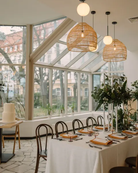 Sala restauracyjna MUDO nakryta do wesela, przeszklenie z widokiem na zieleń