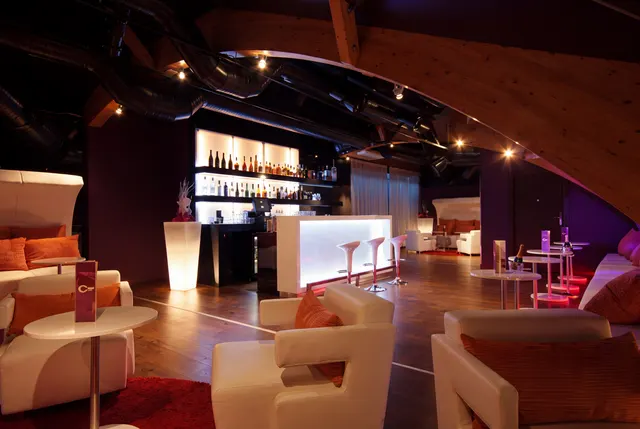 Sala VIP: ciemny bar i białe sofy